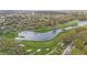 Picturesque aerial view of a golf course with a beautiful pond and lush green fairways surrounded by homes at 6339 Coopers Green Ct, Orlando, FL 32819