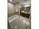 An inviting bathroom with a soaking tub, a separate glass shower, and a granite countertop at 7395 Universal Blvd # 104, Orlando, FL 32819