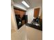A compact kitchen featuring dark countertops, dark wooden cabinets, and a suite of black appliances at 7395 Universal Blvd # 104, Orlando, FL 32819