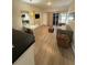 Well-lit living area with a sofa, modern table, and mounted TV, complemented by light wood flooring at 7395 Universal Blvd # 104, Orlando, FL 32819