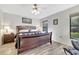 Comfortable bedroom with wood floors, a ceiling fan, and a large window offering natural light and a relaxing ambiance at 7781 Sugar Bend Dr # 7781, Orlando, FL 32819