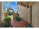 Home entrance with brick walkway, lush greenery, and a charming arched entryway on the side at 7781 Sugar Bend Dr # 7781, Orlando, FL 32819