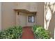 Home entrance with walkway flanked by lush greenery leading to the front door and window at 7781 Sugar Bend Dr # 7781, Orlando, FL 32819