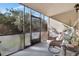 Relaxing screened porch with a comfortable chair and a tranquil view of lush greenery at 7781 Sugar Bend Dr # 7781, Orlando, FL 32819