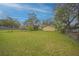 Spacious backyard with green grass, mature trees, shed and chain link fence at 818 Alabama Ave, St Cloud, FL 34769