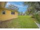 Large backyard, with vibrant green lawn and mature trees providing shade at 818 Alabama Ave, St Cloud, FL 34769