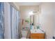 Traditional bathroom with blue shower curtain, vanity, mirror, and neutral wall color scheme at 818 Alabama Ave, St Cloud, FL 34769