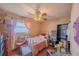 Bedroom with natural light, wood flooring, ornate metal bed frame and ceiling fan at 818 Alabama Ave, St Cloud, FL 34769