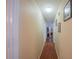 Hallway with wood-look flooring and neutral walls with framed pictures at 818 Alabama Ave, St Cloud, FL 34769