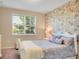 Comfortable bedroom features floral wallpaper accent wall and a white, decorative bedframe at 8321 Bryce Canyon Ave, Windermere, FL 34786