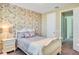 Comfortable bedroom features floral wallpaper accent wall and a white, decorative bedframe at 8321 Bryce Canyon Ave, Windermere, FL 34786