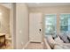 Bright foyer with light wood floors, complemented by a adjacent bathroom and modern gray sofa near the window at 8321 Bryce Canyon Ave, Windermere, FL 34786