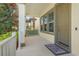 A cozy and inviting covered front porch with white columns, rug, and gray trim around the windows at 8321 Bryce Canyon Ave, Windermere, FL 34786