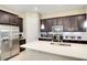 Modern kitchen with stainless steel appliances, white countertops, dark cabinets, and kitchen island at 8321 Bryce Canyon Ave, Windermere, FL 34786