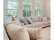 Inviting living room with plush neutral sectional sofa, decorative pillows, and natural light from large windows at 8321 Bryce Canyon Ave, Windermere, FL 34786