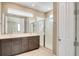 Main bathroom with dual sinks, large mirror, glass shower, and white finishes at 8321 Bryce Canyon Ave, Windermere, FL 34786