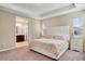 Main bedroom suite with tray ceilings, plush carpet, and a peek into the bathroom at 8321 Bryce Canyon Ave, Windermere, FL 34786