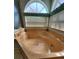 Bathroom with a jacuzzi style soaking tub featuring light filtering blinds and a large arched window at 8630 Knottingham Dr, Kissimmee, FL 34747