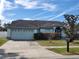 Charming single-story home features a well-maintained front yard and a two-car garage at 8630 Knottingham Dr, Kissimmee, FL 34747