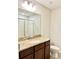 Bathroom vanity with granite counters, dark wood cabinets, and shower in the mirror's reflection at 8923 Azalea Sands Ln, Davenport, FL 33896
