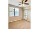 Carpeted bedroom with ceiling fan, large window, and door leading to outside at 8923 Azalea Sands Ln, Davenport, FL 33896