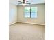 Spacious carpeted bedroom featuring a ceiling fan and a large window at 8923 Azalea Sands Ln, Davenport, FL 33896