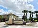 The Champions Club community entrance sign with manicured landscaping and beautiful cloudscape at 8923 Azalea Sands Ln, Davenport, FL 33896