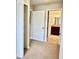 Carpeted hallway with neutral walls, offering a glimpse into the bathroom at 8923 Azalea Sands Ln, Davenport, FL 33896