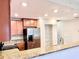 Modern kitchen featuring stainless steel refrigerator, wood cabinets, granite countertops, and pantry at 8923 Azalea Sands Ln, Davenport, FL 33896