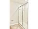 Bathroom featuring tiled shower with glass door and white tile surround at 8923 Azalea Sands Ln, Davenport, FL 33896
