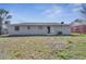 This backyard features a lawn with sparse grass and a modern home with a sliding glass door at 8960 Se 88Th Pl, Ocala, FL 34472