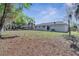 This large backyard is grass-covered and shaded by trees, perfect for outdoor activities at 8960 Se 88Th Pl, Ocala, FL 34472