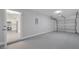 This is a gray painted garage featuring a door into a bright, white kitchen at 8960 Se 88Th Pl, Ocala, FL 34472