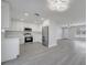 Open-concept kitchen with stainless steel appliances, white cabinetry, and luxury vinyl plank flooring at 8960 Se 88Th Pl, Ocala, FL 34472