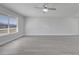 Well-lit living room features luxury vinyl plank flooring, a ceiling fan and a large window at 8960 Se 88Th Pl, Ocala, FL 34472