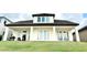 Home's back exterior has a covered patio and a large grassy yard, perfect for outdoor activities at 9207 Busaco Park Way, Winter Garden, FL 34787
