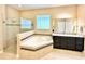 Bright bathroom features a soaking tub, glass enclosed shower and granite topped vanity with ample storage at 9207 Busaco Park Way, Winter Garden, FL 34787