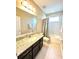 Bathroom features a granite countertop, dark wood cabinets, and a shower-tub combination at 9207 Busaco Park Way, Winter Garden, FL 34787