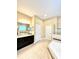 Bright bathroom with a shower, soaking tub, dark vanity with granite counters, and tile flooring at 9207 Busaco Park Way, Winter Garden, FL 34787