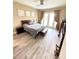 Bedroom featuring a wood frame bed, wood floors, neutral walls, and natural light from french doors at 9207 Busaco Park Way, Winter Garden, FL 34787
