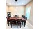 Formal dining room features a wooden table, modern lighting, and ample space for Gathering gatherings at 9207 Busaco Park Way, Winter Garden, FL 34787
