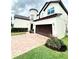 Charming two-story house with a cylindrical tower, brick driveway, and well-maintained yard at 9207 Busaco Park Way, Winter Garden, FL 34787