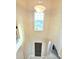 Bright foyer featuring a high ceiling, a striking window, and a view of the front door at 9207 Busaco Park Way, Winter Garden, FL 34787