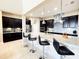 Modern kitchen featuring stainless steel appliances, dark cabinetry, a large island, and stylish pendant lighting at 9207 Busaco Park Way, Winter Garden, FL 34787
