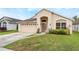 Charming single-story home with a well-maintained lawn, arched entryway, and attached two-car garage at 958 High Point Loop, Longwood, FL 32750