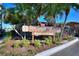 Condominium sign with lush landscaping, palm trees, and a secured gated entrance at 974 E Michigan St # 974, Orlando, FL 32806