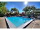 Community pool surrounded by trees and lounge chairs at 974 E Michigan St # 974, Orlando, FL 32806