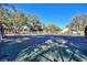 Community tennis court surrounded by lush trees in a sunny outdoor setting at 974 E Michigan St # 974, Orlando, FL 32806