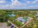 Aerial view of community amenities, including a pool, lake with pier, clubhouse, parking, and lush landscaping at 985 Huntspoint St, Winter Garden, FL 34787