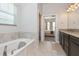 Bathroom showcasing a soaking tub, tiled floors, and a view into the attached bedroom at 985 Huntspoint St, Winter Garden, FL 34787